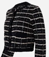 Cardigan cropped negro con diseño de tweed a cuadros blancos, con cuello redondo y cierre frontal con botones esmaltados.