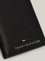 Billetera plegable Tommy Hilfiger de cuero granulado color negro, con múltiples ranuras interiores para tarjetas, compartimento para billetes, cinta distintiva en el interior y logo en la parte delantera.