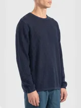 Sweater de algodón negro con diseño de tejido calado, cuello redondo y manga larga.