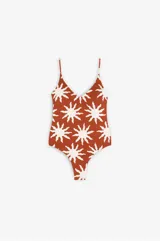 Bañador enterizo con escote en V y espalda abierta, estampado con diseño de soles en color crudo sobre fondo terracota. Cuenta con copas extraíbles y tirantes regulables.