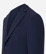 Blazer azul marino de tejido texturizado, con cuello solapa, abotonado delantero, mangas largas y bolsillos. Corte clásico.