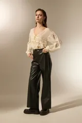 Pantalon de corte recto confeccionado en eco-cuero negro, con tiro medio y costuras horizontales a la altura de la rodilla.