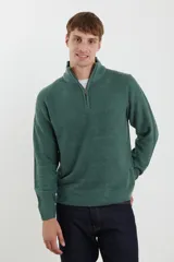Sweater verde de punto inglés con cuello alto y cierre metálico frontal. Tiene mangas largas y terminaciones en punto canalé.
