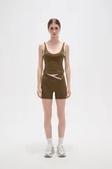 Musculosa deportiva de poliamida, color negro con detalles de ribetes blancos en el cuello y sisas. Presenta un diseño ajustado al cuerpo con escote profundo.