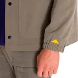 Chaqueta de estilo coach color verde oliva, con cierre frontal a presión, cuello clásico, bolsillos frontales superiores e inferiores y puños elásticos. Presenta etiqueta con logo de la marca en el pecho.