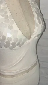 Conjunto de top halter y falda midi al cuerpo, color blanco. El top tiene escote profundo y está decorado con lentejuelas.