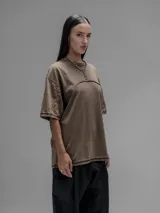 Remera de manga corta con diseño oversize, confeccionada en algodón con proceso batik artesanal en tono óxido. Presenta recortes superpuestos en el frente y costuras expuestas en mangas y cuerpo.