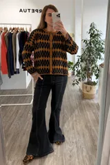 Saco tejido con diseño de rombos en color negro y mostaza, con cuello redondo, cierre frontal de botones y mangas largas.