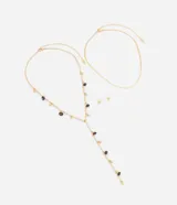 Conjunto de accesorios femenino compuesto por dos collares en capas y un par de aros tipo botón en forma de esfera, en tono dorado. Incluye un collar tipo corbata con abalorios y cuentas oscuras, y una gargantilla de cadena plana tipo cinta.