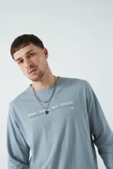 Remera celeste de manga larga con cuello redondo y estampado frontal con texto "New York NY 10038"