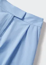 Short de tiro alto con diseño recto y detalle de pinzas frontales. Cuenta con cierre oculto de botón, gancho y cremallera, además de dos bolsillos laterales y bolsillos decorativos en la parte posterior.