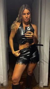 Short negro de cuero sintético con flecos.