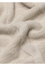 Sweater de punto color beige, de cuello redondo y manga larga, con diseño texturizado de rayas verticales sutiles.
