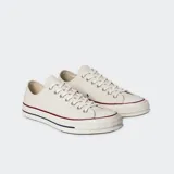 Championes Converse Chuck 70 OX color crema, de caña baja y cordones blancos.