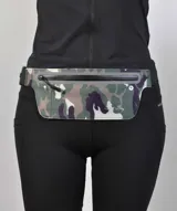 Riñonera deportiva de diseño plano y ergonómico con estampado camuflado. Cuenta con cierre frontal termosellado, salida para auriculares y correa ajustable para la cintura.