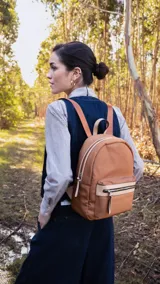 Mochila mediana color rosa, de nylon con detalles en símil cuero en el bolsillo frontal. Tiene asa de mano y correas regulables.