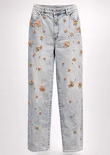 Jean de corte recto confeccionado en denim de lavado claro, decorado con apliques florales brillantes y pequeñas cuentas distribuidas por toda la prenda. Cuenta con cierre de botón y cremallera, además de bolsillos funcionales.