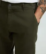Pantalón masculino de corte skinny confeccionado en sarga de algodón con elastano. Presenta cierre frontal con botón y cremallera, cintura con trabillas y bolsillos laterales y traseros.
