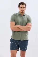Short de baño azul marino con bordado de pequeñas palmeras, cintura elástica con cordón ajustable y bolsillos laterales.