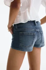 Minishorts de denim de corte ajustado y tiro bajo, con cinco bolsillos, cierre de doble botón y bolsillo monedero con solapa.