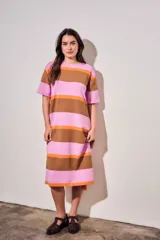 Vestido midi de tejido de punto con diseño de rayas horizontales en tonos rosa, naranja y marrón. Presenta cuello redondo, mangas cortas y un corte holgado con aberturas laterales en el ruedo.