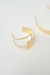 Set de dos brazaletes rígidos abiertos de metal plateado con acabado martillado en la parte frontal y diseño de doble banda.