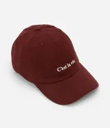 Gorra de sarga color bordó con ala curva y la frase "C'est la vie" bordada en blanco en el frente.