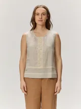 Top sin mangas confeccionado en lino color beige, con cuello redondo y detalles de encaje y puntillas frontales.