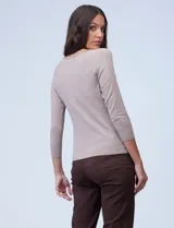 Buzo de tejido fino color beige, con cuello redondo, mangas tres cuartos y diseño raglán.