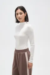 Body de manga larga con cuello alto, confeccionado en tejido al cuerpo.