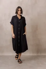 Vestido midi camisero de corte oversize color blanco, con cierre frontal de botones, mangas cortas con vuelta y ruedo redondeado.
