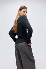 Top de punto interlock pesado con escote bote, manga larga con hombros caídos y bajo asimétrico.