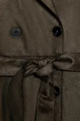 Abrigo largo color marrón oscuro con efecto ante, cuello solapa, manga larga con trabillas en los hombros y bolsillos delanteros de vivo. Presenta un bajo con abertura en la espalda y cierre frontal cruzado con botones, complementado con un cinturón a tono.