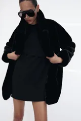 Abrigo de Zara con efecto pelo, cuello de solapa con muescas, manga larga y bolsillos delanteros. Cuenta con forro interior a tono y cierre frontal mediante ganchos metálicos.