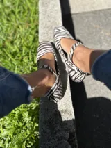 Zapatos tipo Mary Jane con estampado de cebra en pelo sintético, con correa sobre el empeine y hebilla metálica.