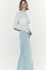 Jean de denim celeste de tiro alto con piernas amplias, bolsillos delanteros de parche y raya marcada al frente y en la espalda.