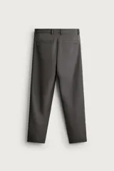 Pantalón regular fit de hombre color negro, confeccionado en tejido técnico ligero con cintura elástica, bolsillos frontales, bolsillos traseros de vivo y cierre frontal con cremallera y botón.