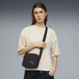 Bandolera Puma modelo HER, color negro, con cierre principal y bolsillo frontal con cierre. Incluye correa ajustable y logo de la marca bordado en el frente.