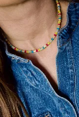 Gargantilla de cuentas pequeñas en colores vibrantes como amarillo, fucsia, azul y blanco, con diseño tipo choker.