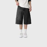 Bermuda de jean estilo baggy, color negro gastado, con diseño amplio y costuras pespunteadas visibles.
