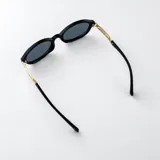 Lentes de sol con armazón ovalado estilo carey (tortoise) en tonos marrones y negros, con detalles metálicos dorados en las patillas y lentes degradados en tono marrón.