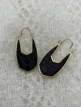 Par de aros colgantes con forma geométrica, con interior de cuero sintético negro con textura de piel de cocodrilo y borde dorado.