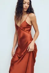 Vestido midi de tejido satinado color terracota, con escote en pico, tirantes finos ajustables y espalda con tiras cruzadas.
