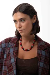Collar corto de cuentas de piedras naturales, cristales checos y cuentas reconstituidas en tonos rojos, azules y jaspeados. Incluye cadena de acero quirúrgico para ajuste de largo.