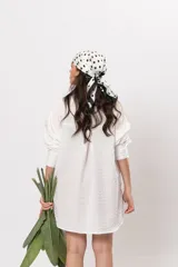 Camisa amplia blanca con bolsillos frontales gigantes y cierre frontal con botones.