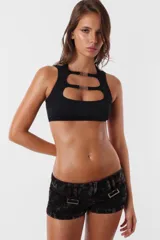 Microshort de gabardina de tiro bajo y corte slim fit. Presenta costuras en contraste color rojo, cierre metálico frontal y presillas largas en la cintura. La prenda cuenta con un proceso de sobreteñido y lavado artesanal que le otorga un aspecto desgastado único.