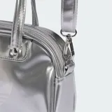Mini bolso estilo bowling Adidas Adicolor plateado con acabado metalizado, asas de mano y correa desmontable. Presenta el logotipo del Trifolio grabado en la parte frontal.