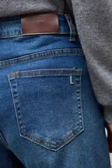 Jean de corte flare con tiro medio, confeccionado en denim azul clásico con costuras a contratono.