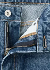 Jeans estilo wide leg de tiro medio con diseño de cinco bolsillos, trabillas para cinturón, cierre de botón y cremallera, y bajo vuelto.