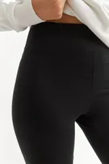 Calza capri negra de algodón y lycra, con cintura alta elástica.